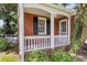 Classic brick porch with white railings, black shutters, and established landscaping at 727 Savannah Hwy, Charleston, SC 29407