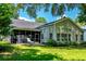 Back of house with large screened-in porch, patio, well manicured lawn, and abundant sunlight at 808 Long Drive Rd, Summerville, SC 29485