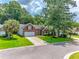 Inviting two-story brick home with a two-car garage, lush green lawn, and mature trees at 808 Long Drive Rd, Summerville, SC 29485