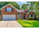 Charming red brick home with an attached two-car garage and a well-manicured lawn and flower bed at 808 Long Drive Rd, Summerville, SC 29485
