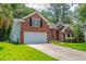 Charming two-story red brick home with two car garage, beautiful landscaping, and manicured front lawn at 808 Long Drive Rd, Summerville, SC 29485