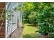 Side yard featuring manicured lawn, mature trees, and a brick-and-siding exterior at 808 Long Drive Rd, Summerville, SC 29485