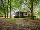 Backyard view with screened porch, mature trees, and partial lawn, offering a serene outdoor living space at 8316 Dye Makers, North Charleston, SC 29418