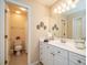 Bright bathroom with white cabinets, silhouetted art, and framed mirror at 8316 Dye Makers, North Charleston, SC 29418