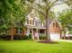 Charming two-story home featuring a brick facade, white trim, and a well-manicured lawn with mature trees at 8316 Dye Makers, North Charleston, SC 29418