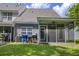 View of a backyard with an enclosed porch, green grass, and mature trees on a bright, sunny day at 8721 Grassy Oak Trl, North Charleston, SC 29420