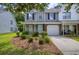 Charming two-story townhouse featuring a light blue front door, white garage door, and well-manicured landscaping at 8721 Grassy Oak Trl, North Charleston, SC 29420