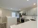 Well-lit kitchen with stainless steel appliances, light gray cabinetry, and white subway tile backsplash at 8721 Grassy Oak Trl, North Charleston, SC 29420