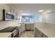 Modern kitchen with stainless steel appliances, sleek countertops, subway tile backsplash, and an open view to the living area at 8721 Grassy Oak Trl, North Charleston, SC 29420