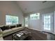 Bright living room features vaulted ceilings, modern furnishings, large windows, and rich wood floors at 8721 Grassy Oak Trl, North Charleston, SC 29420