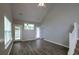 Open-concept living room with vaulted ceilings, laminate floors, and multiple windows for natural light at 8721 Grassy Oak Trl, North Charleston, SC 29420