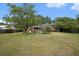 Backyard view featuring mature trees, a well-kept lawn, and the home's exterior with a small patio at 943 Mikell Dr, Charleston, SC 29412