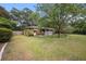 Spacious backyard with lush greenery, mature trees, a charming patio, and a well-maintained lawn at 943 Mikell Dr, Charleston, SC 29412