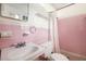 The bathroom features a pink ceramic tile wall, a shower and bright lighting at 943 Mikell Dr, Charleston, SC 29412