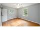 Bedroom with hardwood floors, two windows, and ceiling fan provides natural light and ventilation at 943 Mikell Dr, Charleston, SC 29412