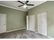 Neutral bedroom featuring gray carpet, a ceiling fan, and white closet doors at 10 Stallion Ct, Charleston, SC 29407