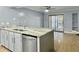 Bright kitchen featuring white cabinets, stainless steel appliances, and view into the living room at 10 Stallion Ct, Charleston, SC 29407
