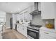 Modern kitchen with white cabinets, stainless steel appliances, and light hardwood floors at 101 Hanover St, Charleston, SC 29403
