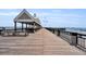 Inviting wooden pier with covered seating areas extending into the ocean, offering a tranquil retreat at 101 Hanover St, Charleston, SC 29403