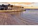 Beautiful waterfront property at sunset, reflected in the water, with palm trees and dock at 101 Hanover St, Charleston, SC 29403