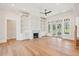 Open living room featuring hardwood floors, fireplace, built-in bookshelves, and a ceiling fan at 105 Peninsula Dr, Ravenel, SC 29470