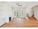 Open living room with hardwood floors, fireplace, built-in bookshelves, and staircase at 105 Peninsula Dr, Ravenel, SC 29470