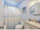Cozy blue bathroom featuring a vanity with a granite countertop, a rounded mirror, and a shower with a seashell-themed curtain at 106 Nottingham Ct, Summerville, SC 29485