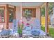 Inviting front porch with blue rocking chairs, flowers, and patriotic decor for a cozy, welcoming entrance at 106 Nottingham Ct, Summerville, SC 29485