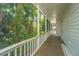 Spacious balcony with white railings offers panoramic views of the lush, tropical foliage at 11 49Th Ave, Isle of Palms, SC 29451