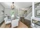 Elegant dining room with glass table, modern chandelier, and staircase access offers seamless flow at 11 49Th Ave, Isle of Palms, SC 29451