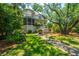 Charming two-story home with a screened porch, pretty landscaping and a brick and grass walkway at 11 49Th Ave, Isle of Palms, SC 29451