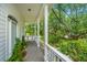 Outdoor porch with a swing and railings overlooking lush green trees at 11 49Th Ave, Isle of Palms, SC 29451
