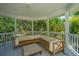 Covered porch with wood furnishings offers a relaxing outdoor living space with lush green views at 11 49Th Ave, Isle of Palms, SC 29451