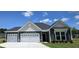 Charming single-story home with a two-car garage and well-maintained landscaping under a blue sky at 111 Captains Creek Ln, Ridgeville, SC 29472