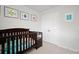 Bedroom featuring a dark wood crib, closet, and playful fish artwork on light gray walls at 1115 Fitzgerald Ct, Summerville, SC 29485