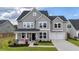 Charming two-story home with gray siding, front porch, manicured lawn, and a two-car garage at 1115 Fitzgerald Ct, Summerville, SC 29485