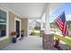 Welcoming front porch with brick accents, manicured landscaping, and a waving American flag at 1115 Fitzgerald Ct, Summerville, SC 29485
