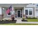Inviting front porch with brick accents, American flag, and colorful flower arrangements adding curb appeal at 1115 Fitzgerald Ct, Summerville, SC 29485