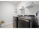 Laundry room showcasing modern black Samsung washer and dryer set with overhead shelving at 1115 Fitzgerald Ct, Summerville, SC 29485