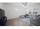 Cozy living room with large gray sectional, TV, windows, and light-filled open floor plan at 1115 Fitzgerald Ct, Summerville, SC 29485