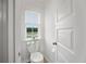 Powder room featuring toilet, window with blinds, and white door at 1115 Fitzgerald Ct, Summerville, SC 29485