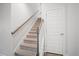 Carpeted staircase with gray wood banister and white wood trim leads to the second story at 1115 Fitzgerald Ct, Summerville, SC 29485