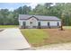 Inviting single-story house boasts a concrete driveway, well-manicured lawn, and a modern white facade with brick accents at 112 Southsong Ln, Goose Creek, SC 29445