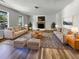 Spacious living room featuring neutral sofas, ottomans, fireplace, large windows, and stylish rug at 120 Apache Dr, Summerville, SC 29483