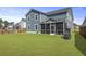 Expansive backyard featuring a well-maintained lawn and screened-in porch on the rear of the blue home at 120 Haverhill St, Summerville, SC 29486