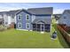 The manicured backyard highlights a blue two-story home with an inviting screened porch at 120 Haverhill St, Summerville, SC 29486