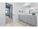 Neutral bathroom featuring a gray vanity, large mirror, open doorway, and decorative accessories at 120 Haverhill St, Summerville, SC 29486