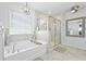 Luxurious bathroom featuring a soaking tub, a glass-enclosed shower, and elegant lighting fixtures at 120 Haverhill St, Summerville, SC 29486
