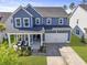 Stunning two-story home featuring blue siding, a two-car garage, and a welcoming front porch with comfortable seating at 120 Haverhill St, Summerville, SC 29486