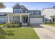 Charming two-story home with blue siding, a two-car garage, and a welcoming front porch with seating at 120 Haverhill St, Summerville, SC 29486